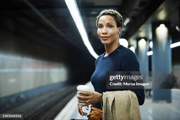 businesswoman waiting for train at subway station - real ストックフォトと画像