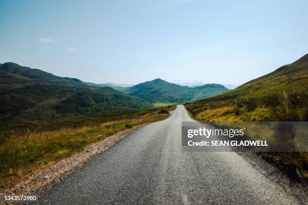 empty summer highlands road - mountain roads stock pictures, royalty-free photos & images