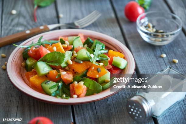 salad of chopped raw vegetables. chopped tomatoes and cucumbers, with the addition of pine nuts. vegetarian, vegan and raw food food and diet. - low carb diet - fotografias e filmes do acervo