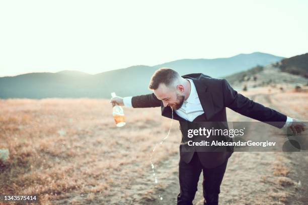 drunk male puking and holding bottle in hand after bachelor's party - vomit stock pictures, royalty-free photos & images