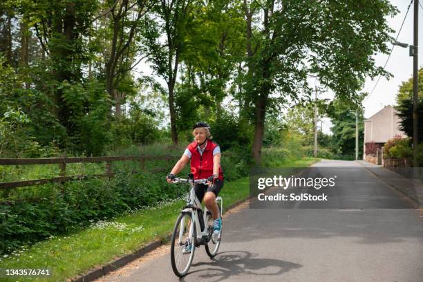 cycling through a village - e bike stock pictures, royalty-free photos & images