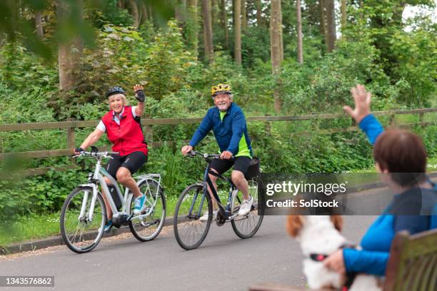 couple cycling through town - community safety stock pictures, royalty-free photos & images