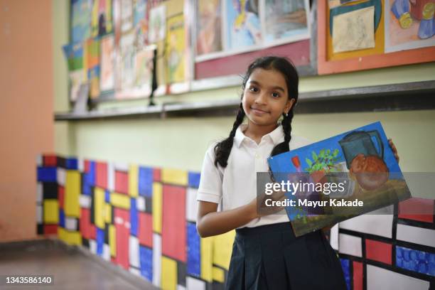 portrait of a school girl holding her still life painting  in art room - schoolgirl photos et images de collection