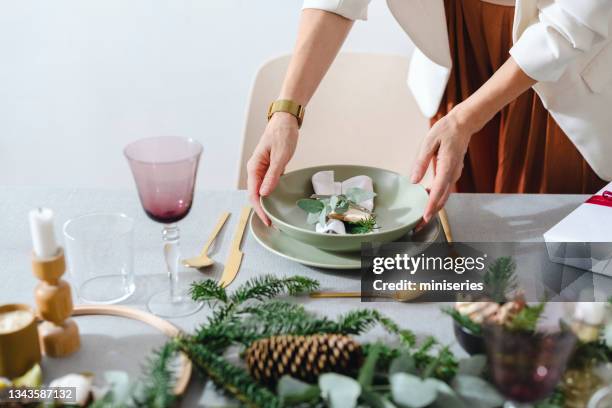 an anonymous woman setting up christmas dinner table - christmas party host stock pictures, royalty-free photos & images