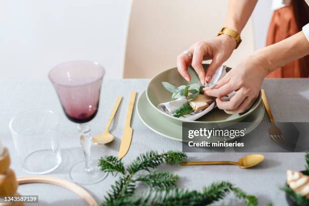 christmas celebration: an anonymous woman setting up christmas dinner table - party host imagens e fotografias de stock