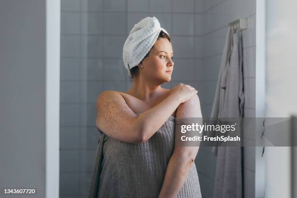 hermosa mujer de talla grande que se aplica loción corporal después de tomar una ducha - wet look fotografías e imágenes de stock