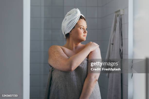 hermosa mujer de talla grande que se aplica loción corporal después de tomar una ducha - ducharse fotografías e imágenes de stock