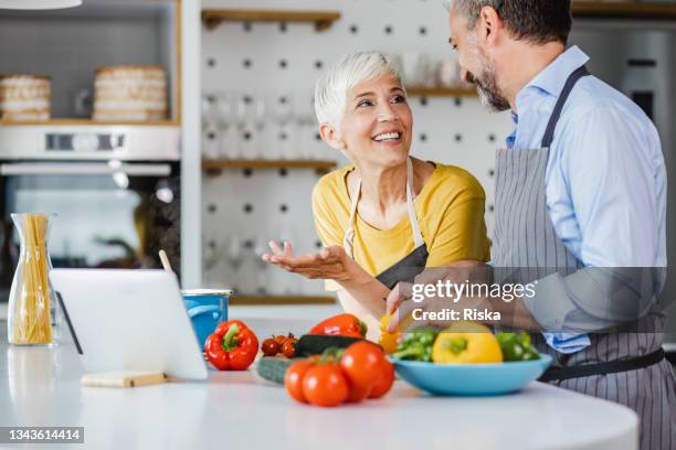 家庭で成熟したカップル, 一緒に食事を準備 - middle aged couple cooking ストックフォトと画像