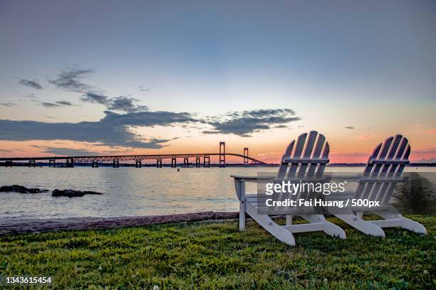 empty chairs on beach against sky during sunset,newport,rhode island,united states,usa - rhode island bridge stock pictures, royalty-free photos & images