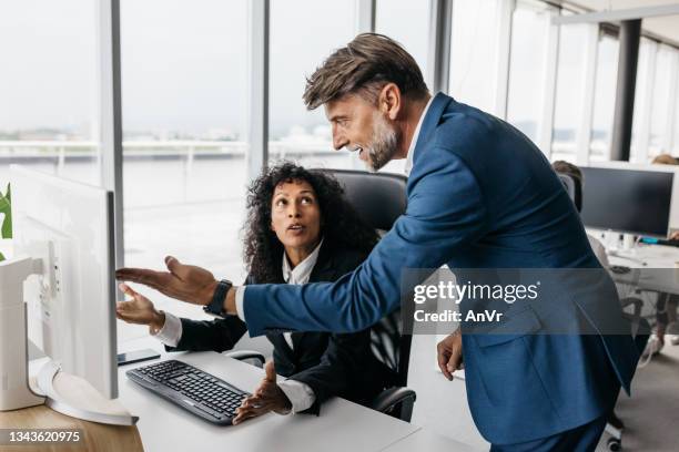 business woman and businessman having a heated discussion - male victim stock pictures, royalty-free photos & images