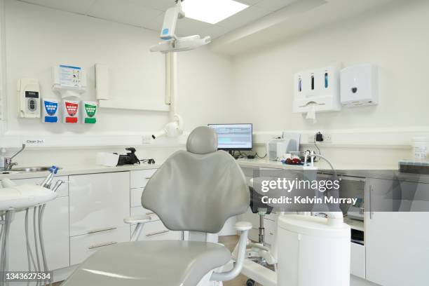 modern clean dental surgery with dental chair and dental equipment - in dentist chair stock pictures, royalty-free photos & images