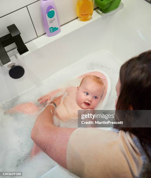 mother bathing baby girl - woman bath tub wet hair stock pictures, royalty-free photos & images