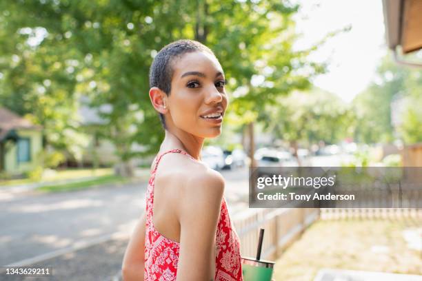 young woman standing outside her house on residential street - shaved head stock pictures, royalty-free photos & images