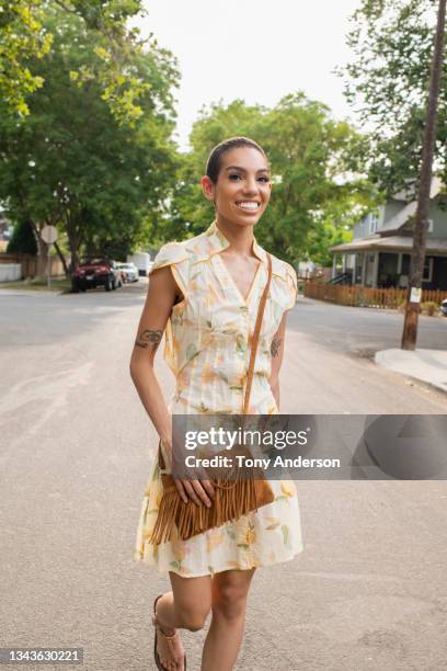 young woman  walking on residential street - white purse stock pictures, royalty-free photos & images