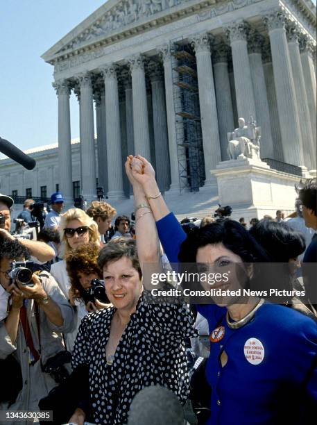 American activist Norma McCorvey and attorney Gloria Allred each raise an arm during a rally on the front steps of the US Supreme Court, Washington...