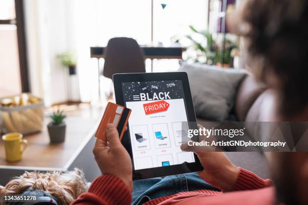hombre comprando electrónica en línea durante la venta del black friday. - black friday fotografías e imágenes de stock