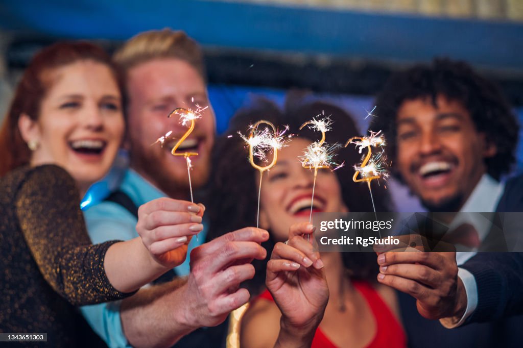 Smiling people holding sparklers