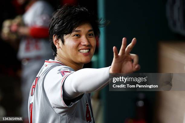 Shohei Ohtani of the Los Angeles Angels gestures to a teammate in the dugout before taking on the Texas Rangers at Globe Life Field on September 28,...