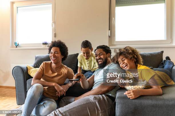 famiglia afroamericana che guarda un film a casa. - african watching tv foto e immagini stock