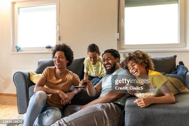 african american family watching a movie at home. - family television stock pictures, royalty-free photos & images
