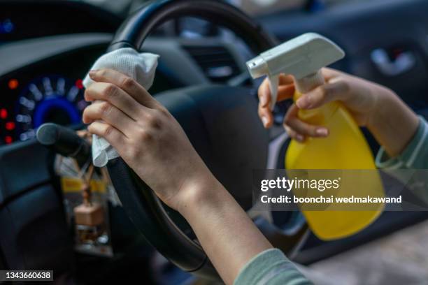 close-up of woman's hand is cleaning car with alcohol spray - interior del vehículo fotografías e imágenes de stock