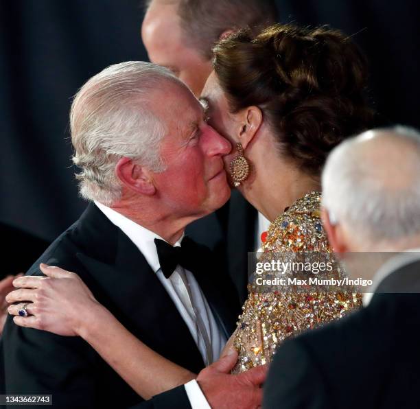 Prince Charles, Prince of Wales kisses Catherine, Duchess of Cambridge as they arrive to attend the "No Time To Die" World Premiere at the Royal...