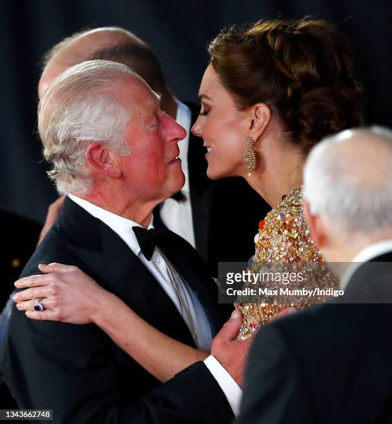 Prince Charles, Prince of Wales kisses Catherine, Duchess of Cambridge as they arrive to attend the "No Time To Die" World Premiere at the Royal...