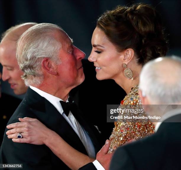 Prince Charles, Prince of Wales kisses Catherine, Duchess of Cambridge as they arrive to attend the "No Time To Die" World Premiere at the Royal...