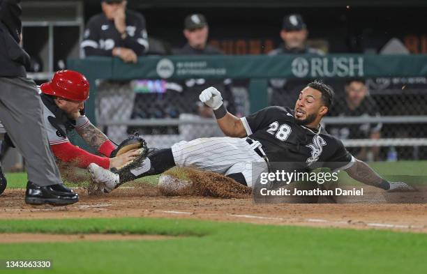 Leury Garcia of the Chicago White Sox is tagged out at the plate by Tucker Barnhart of the Cincinnati Reds trying for an inside the park home run in...