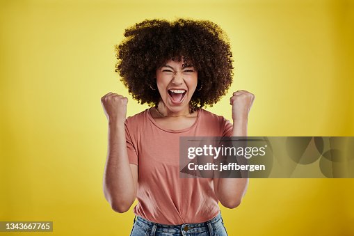 Prise de vue en studio d’une jolie jeune femme à l’air excité sur un fond jaune Prise de vue en studio d’une jolie jeune femme à l’air excité sur un fond jaune