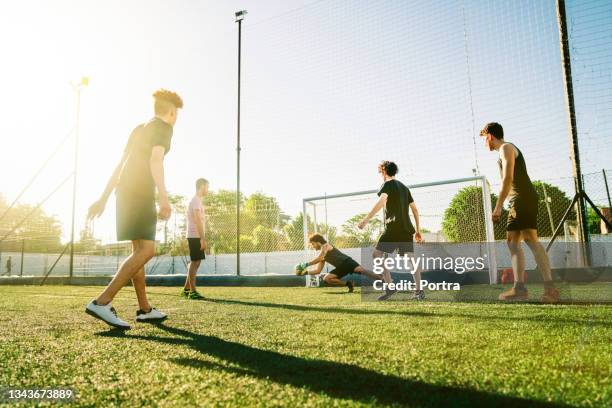 male goalie defending ball at soccer field - young men playing soccer stock pictures, royalty-free photos & images