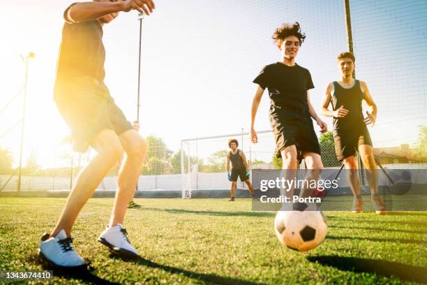 männliche spieler, die im sommer auf dem feld fußball spielen - amateur stock-fotos und bilder