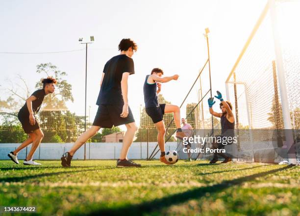 soccer players together at field during sunny day - verdediger voetballer stockfoto's en -beelden