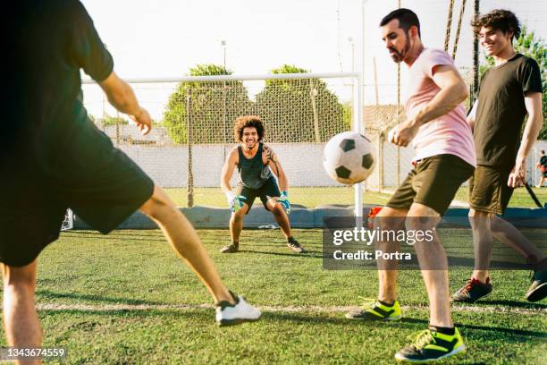 spieler, die an sonnigen tagen fußball spielen - amateur stock-fotos und bilder