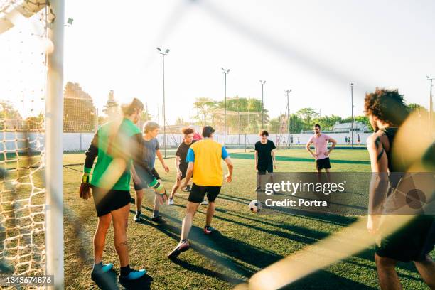 atletas practicando fútbol durante el día soleado - amateur football fotografías e imágenes de stock