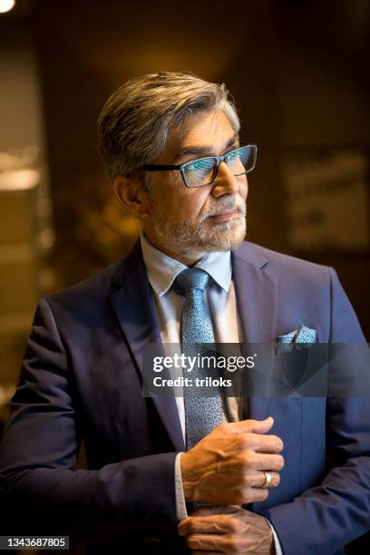 businessman fixing cuff links of his shirt - cufflinks stockfoto's en -beelden