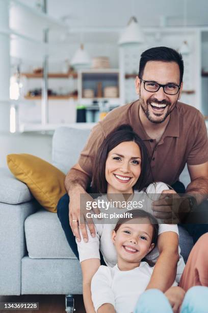 ritratto di una bella famiglia con un bambino a casa - allegro foto e immagini stock