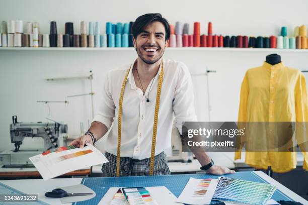 alegre diseñador de moda sosteniendo muestras de color - design professional fotografías e imágenes de stock