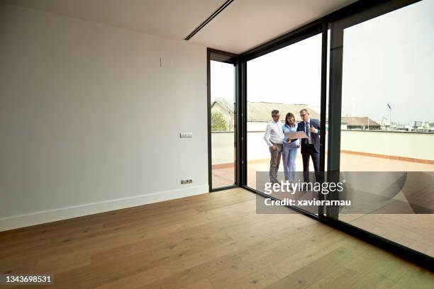real estate agent showing floor plan to prospective buyers - grounds imagens e fotografias de stock