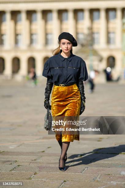 Julia Comil wears a black wool beret with lace detail from Dior, gold pearl earrings, a large pearls earring, a gold chain necklace, a black puffy...