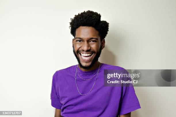 retrato de un joven barbudo sonriendo mirando a la cámara. - gay young men fotografías e imágenes de stock