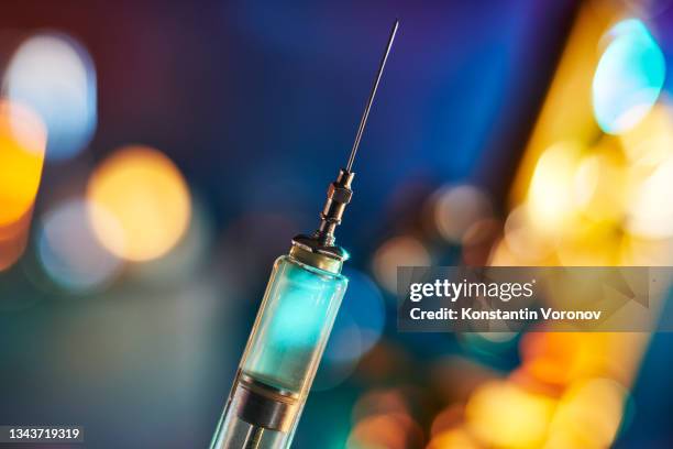 antique reusable syringe filled with blue liquid. - drogados imagens e fotografias de stock