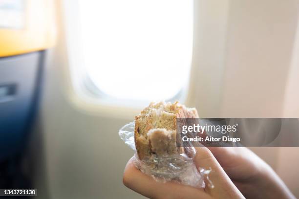 a person eats a snack inside an airplane while flying. - airline food stock-fotos und bilder