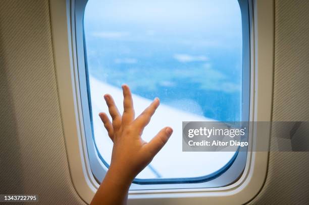 a person (child)  has the hand on the window of an airplane while flying. - waving hands goodbye photos et images de collection