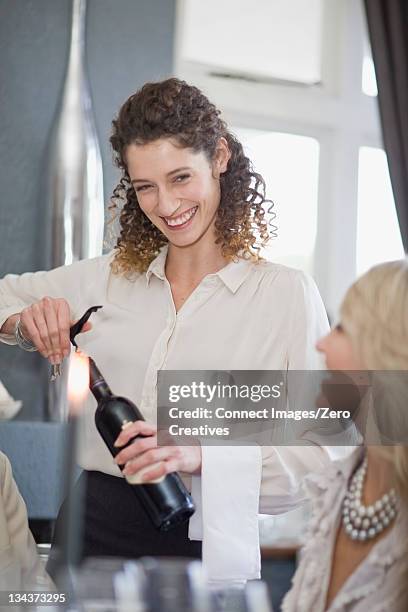 waitress uncorking wine in restaurant - cavatappi foto e immagini stock