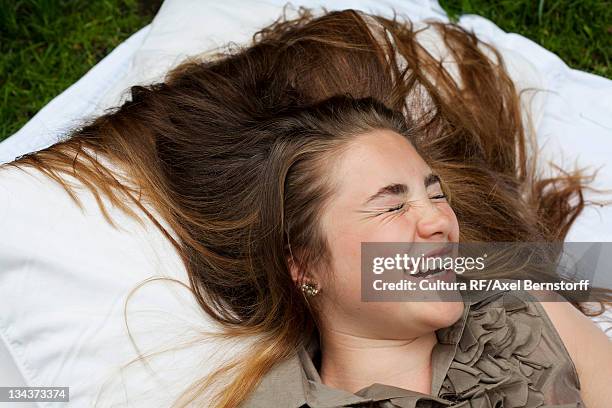 teenage girl laughing on pillows - 14 year old brunette girl stock pictures, royalty-free photos & images