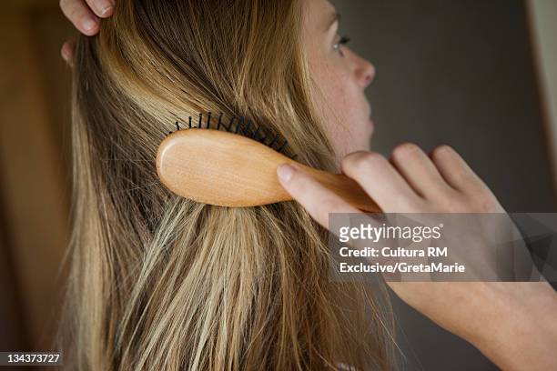 close up of woman brushing her hair - brush in woman's hair stock pictures, royalty-free photos & images