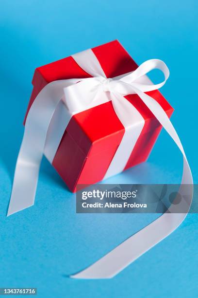 beautiful red gift box against blue background - birthday gift stock pictures, royalty-free photos & images