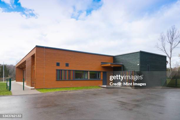 a modern building, a pre-school entrance and playground - school building exterior stock-fotos und bilder