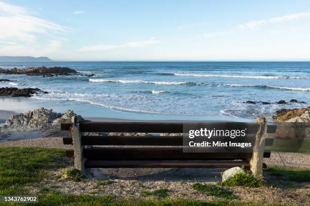 bench overlooking a beach, jagged rocks and rockpools on the atlantic coast. - bench sea stock-fotos und bilder